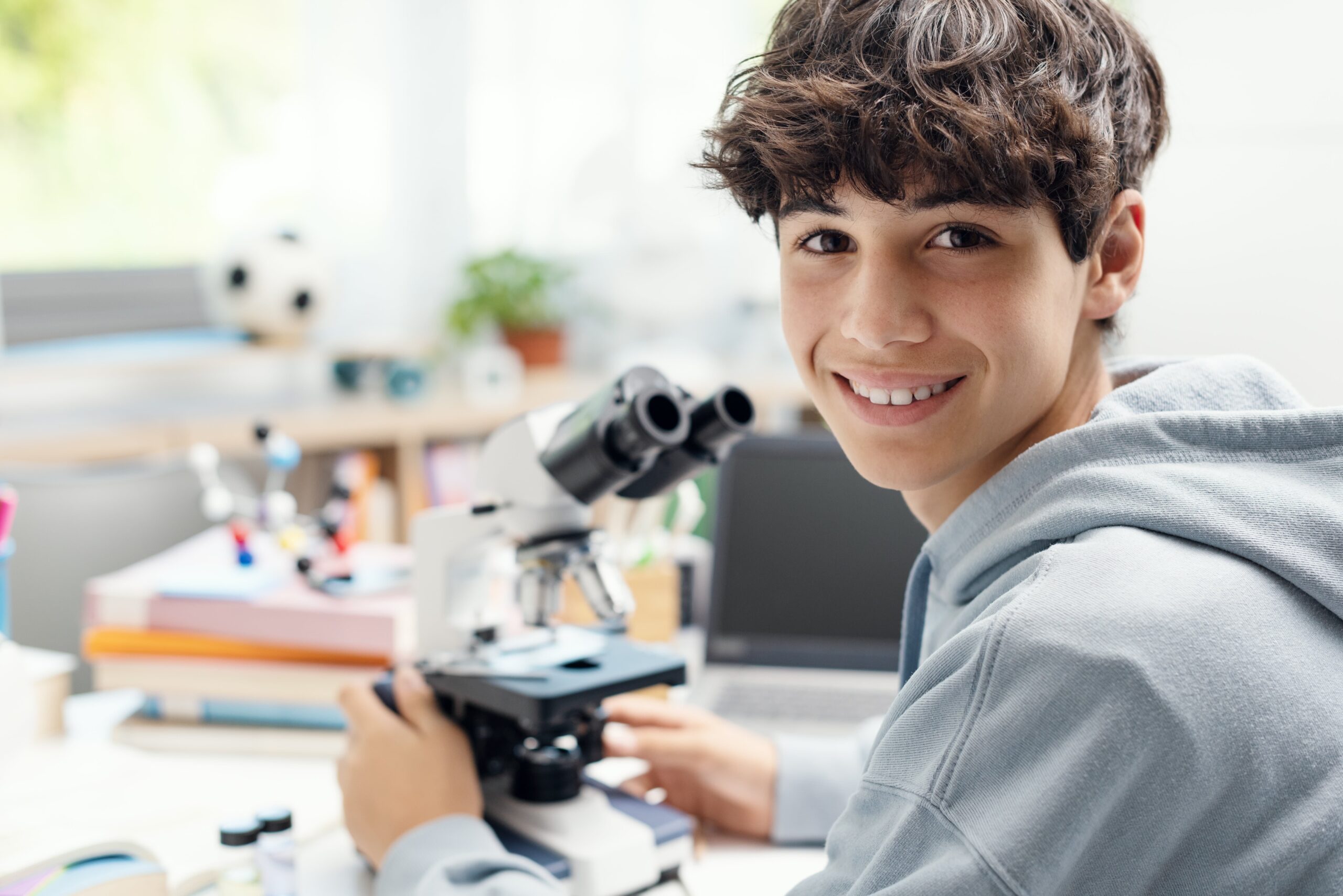 A Happy Student Uses a Microscope